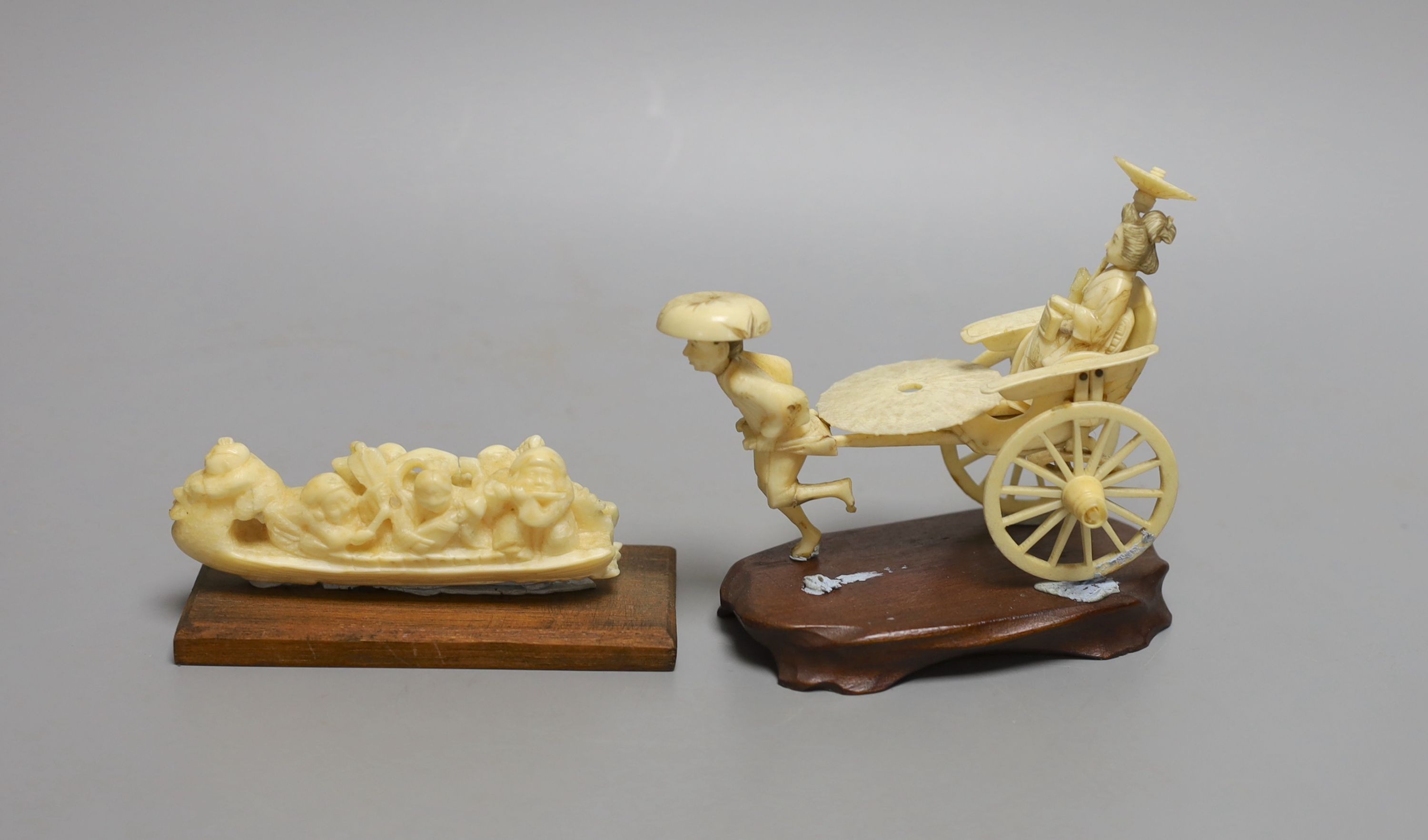 A Japanese ivory rickshaw group and a walrus ivory okimono of three immortals and attendants in a boat, early 20th century (2) wood stands - tallest 11cm tall